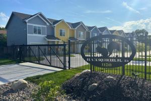 a gate with a sign in front of a house at 2 Beds, Built-in Office, Gated Entry in Council Bluffs