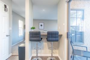 a kitchen with two chairs and a counter in a room at Boulevard Stays Tranquil 1BR King Suite Pool Gym Parking 01 in Dallas