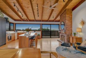 a large kitchen with a vaulted ceiling and a fireplace at Mid Century on Eastview in Torquay
