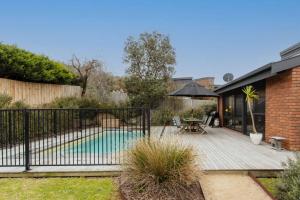 a backyard with a swimming pool and a fence at Mid Century on Eastview in Torquay