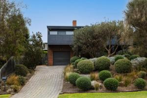a house with a driveway and a garage at Mid Century on Eastview in Torquay