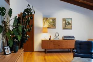 a living room with a blue chair and a wooden cabinet at Mid Century on Eastview in Torquay +25 photos