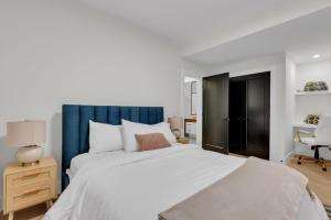 Un dormitorio con una gran cama blanca y una silla. en Cozy 1BR Pullout Couch Discovery Ridge, en Calgary