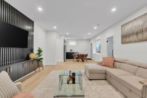 Una sala de estar con un sofá y un televisor. en Cozy 1BR Pullout Couch Discovery Ridge, en Calgary