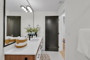 un baño con lavabo y espejo en Cozy 1BR Pullout Couch Discovery Ridge, en Calgary
