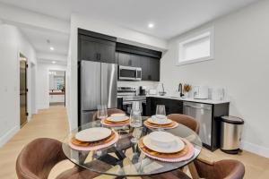 cocina con mesa de cristal y algunas sillas en Cozy 1BR Pullout Couch Discovery Ridge, en Calgary 15 fotos más