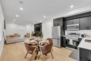 Una cocina y una sala de estar con mesa y sillas. en Cozy 1BR Pullout Couch Discovery Ridge, en Calgary