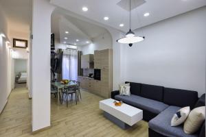 a living room with a blue couch and a table at Bedda Sicily in Riposto