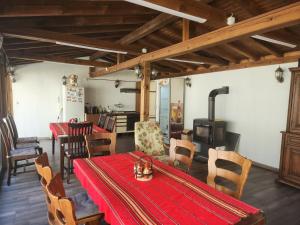 a dining room with a red table and a stove at Еребор in Tryavna