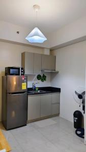 a kitchen with a stainless steel refrigerator and a sink at Bella Suite Netflix Pool Great View in Manila