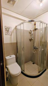 a bathroom with a shower with a toilet and a sink at Bella Suite Netflix Pool Great View in Manila