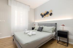 a white bedroom with a large bed with white sheets at Segrate - Milano Due Appartamento di Lusso con Vista Lago in Segrate