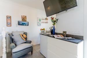 un bar avec une chaise et une télévision murale dans l'établissement City center Studio penthouse near the beach, à Puerto de la Cruz