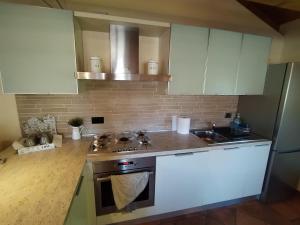 a kitchen with white cabinets and a sink at Blumen Haus in Gorizia