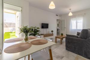 a living room with a table and a couch at Allo Apartments Ático Jaramago Parking Centro 1 Hab in Jerez de la Frontera