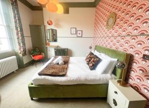 a bedroom with a bed with a red wall at The Half Angel apartment at The Bank of England in Bristol