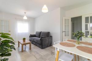 a living room with a couch and a table at Allo Apartments Ático Jaramago Parking Centro 1 Hab in Jerez de la Frontera
