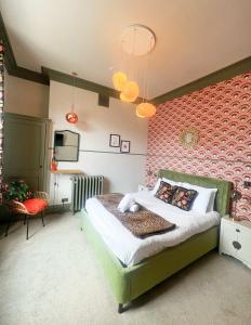 a bedroom with a bed and a red wall at The Half Angel apartment at The Bank of England in Bristol +3 photos