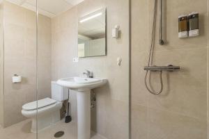 a bathroom with a toilet and a sink and a shower at Allo Apartments Ático Jaramago Parking Centro 1 Hab in Jerez de la Frontera +20 photos