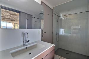 een witte badkamer met een wastafel en een douche bij La Baume du Delà in Saint-Chamas +23 foto's