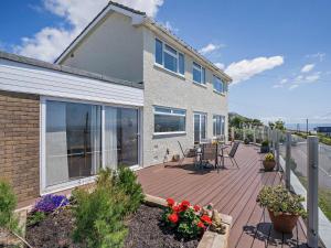 eine Terrasse mit einem Tisch und Stühlen auf einem Haus in der Unterkunft 4 Bed in Ogmore-by-Sea 74236 in Saint Brides Major