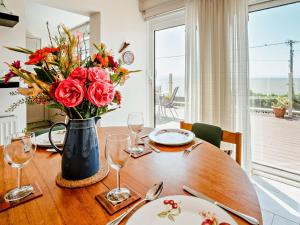 ein Holztisch mit einer Vase mit Blumen darauf in der Unterkunft 4 Bed in Ogmore-by-Sea 74236 in Saint Brides Major