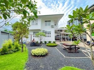 a person sitting in the courtyard of a building at White & Green Guesthouse in Bangkok Yai