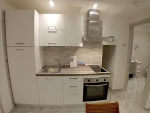 een keuken met witte kasten en een spoelbak bij Al Borgo in Riano