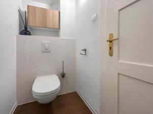a white bathroom with a toilet and a door at Family Lounge proche de Europapark et Rulantica in Rhinau +34 photos