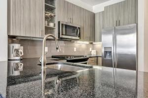 Una cocina con fregadero y frigorífico de acero inoxidable. en Boulevard Stays Dashing 1BR Suite Pool Parking Gym C, en Richardson 25 fotos más