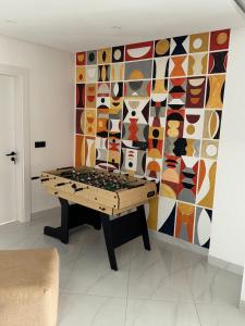 Habitación con mesa y pared de mosaico en Piscine à débordement, Rooftop, Vue Mer & Babyfoot, en Dakar