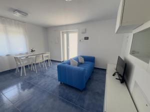 Una sala de estar con un sofá azul y una mesa. en Casa Buono Holidays, en Isquia