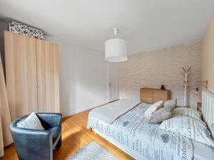 a bedroom with a bed and a chair at Family Lounge proche de Europapark et Rulantica in Rhinau
