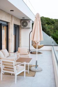 a patio with a table and an umbrella on a balcony at sea and sun luxury apartment in Ulcinj