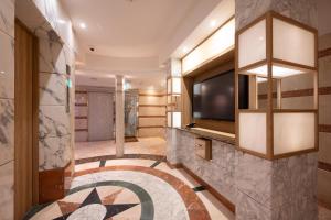 Un vestíbulo de hotel con televisión y un gran suelo de baldosas. en BE FREE HOTELS甲府は2025年8月にカップル専用のホテルをフルリノベーションした まったく新しいスタイルのホテルです様々なご利用者様の自由な過ごし方を提供するホテルとしてBE FREE HOTELsと名付けました, en Showa