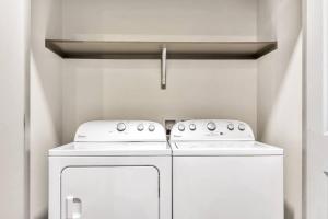 a kitchen with two white washers and a refrigerator at Boulevard Stays Bright 1BR Suite Pool Parking Gym J in Richardson +24 photos