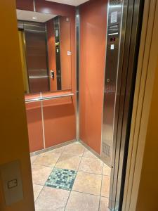 La salle de bains est pourvue d'une douche à l'italienne et de murs orange. dans l'établissement Appartement frejus, à Fréjus