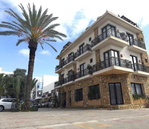 a building with a palm tree in front of it at Palm Surf & Spa Hotel Agadir in Agadir