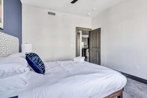 a bedroom with a white bed with a blue wall at Boulevard Stays Dashing 1BR Suite Pool Parking Gym H in Richardson +27 photos