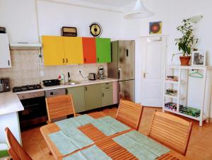 a kitchen with colorful cabinets and a table and chairs at B59 guesthouse in Budakalász