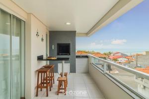 a balcony with a view of the ocean at Apto Vista Mar Lateral a 120m da Praia EEI0303 in Itajubá