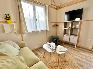 un soggiorno con un divano e due tavoli di BERCK-PLAGE - 4 Hébergements insolites Tiny House de 2 à 18 personnes a Berck-sur-Mer