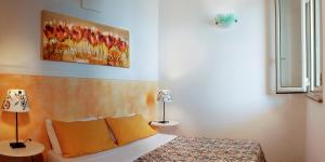 una camera da letto con un letto e un quadro sul muro di Il Corbezzolo Casa Vacanza a Santa Cesarea Terme