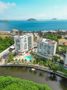 an aerial view of a resort and the ocean at Apartamento com piscina a poucos passos da praia in Niterói