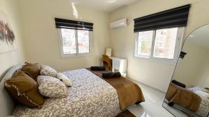 a bedroom with a bed and two windows at Luxury 2 Bedroom Apartment in Central Larnaca in Faneromeni Area in Larnaka