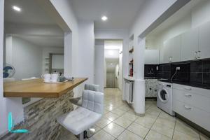 a kitchen with white cabinets and a table and a washing machine at Chiabrera11 Aquarium - Genovainrelax in Genova