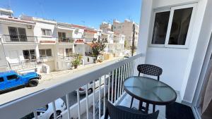 a balcony with a table and chairs and a view of a street at Luxury 2 Bedroom Apartment in Central Larnaca in Faneromeni Area in Larnaka