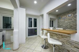 a kitchen with a counter and two white chairs at Chiabrera11 Aquarium - Genovainrelax in Genova
