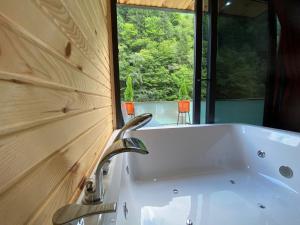 a bathroom with a sink and a window and a tub at Yeşilton Tatil Köyü & Bungalov in Çamlıhemşin +50 photos