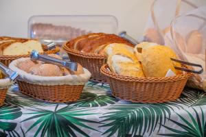 a bunch of baskets of bread on a table at VELINN Feiticeira Praia Hotel in Ilhabela +31 photos